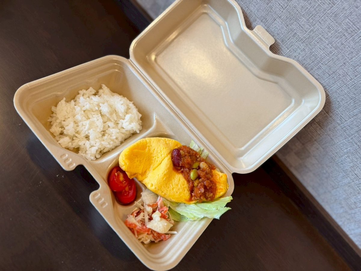お弁当を前にピースをする男の子